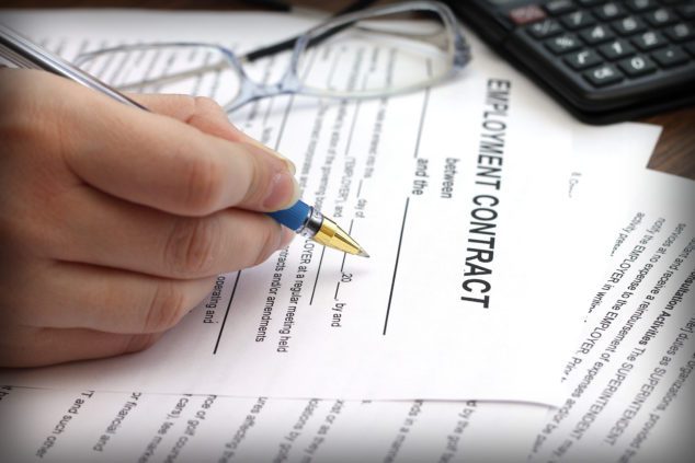 woman's hands signing an employment contract, close-up